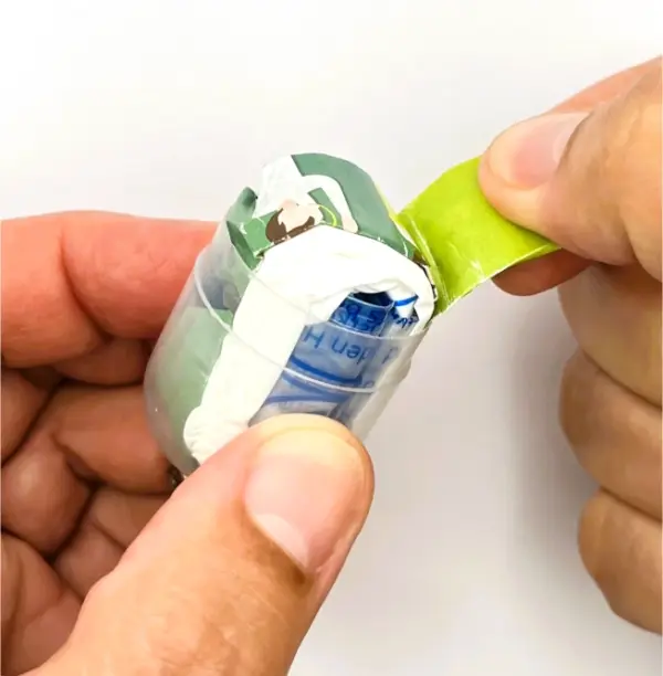 Notfall-Set-fuer-unterwegs-als-RettEi-Original-via-Erste-Hilfe-Schluesselanhaenger-mit-Beatmungstuch-zur-Mund-zu-Mund-Beatmung-mit-transparent-Kapsel-geoeffnet.