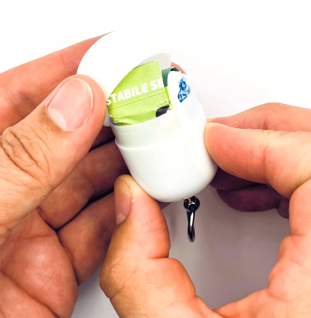 Erste-Hilfe-Set-als-Streuartikel-–-ideal-als-Giveaway-personalisiertes-Kundengeschenk-Notfallset-mit-Logo-bedrucken-lassen-mit-weißer-Kapsel-teilweise geöffnet